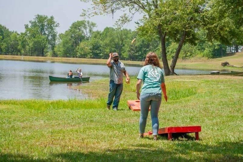 Couple engaged in a game of cornhole at Kick Back Ranch, one of the top RV parks near Montgomery, A