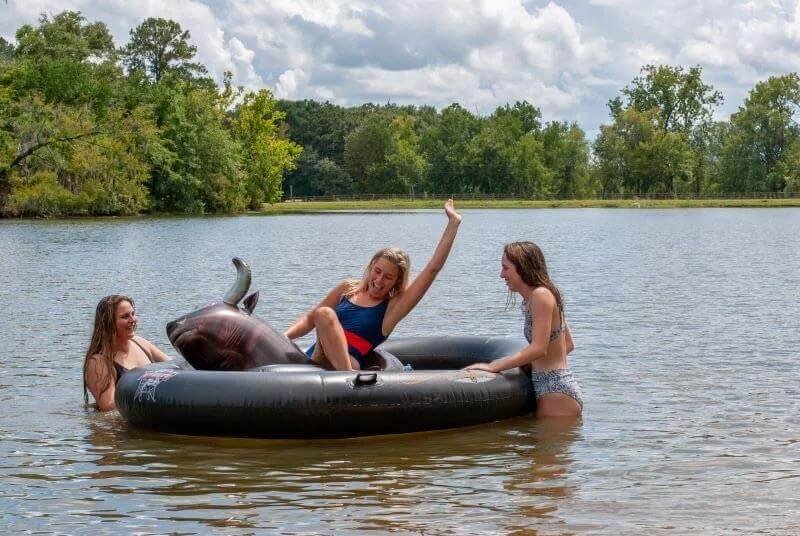 Inflatable bull ride on lake at Kick Back Ranch, family-friendly campground near Montgomery, A